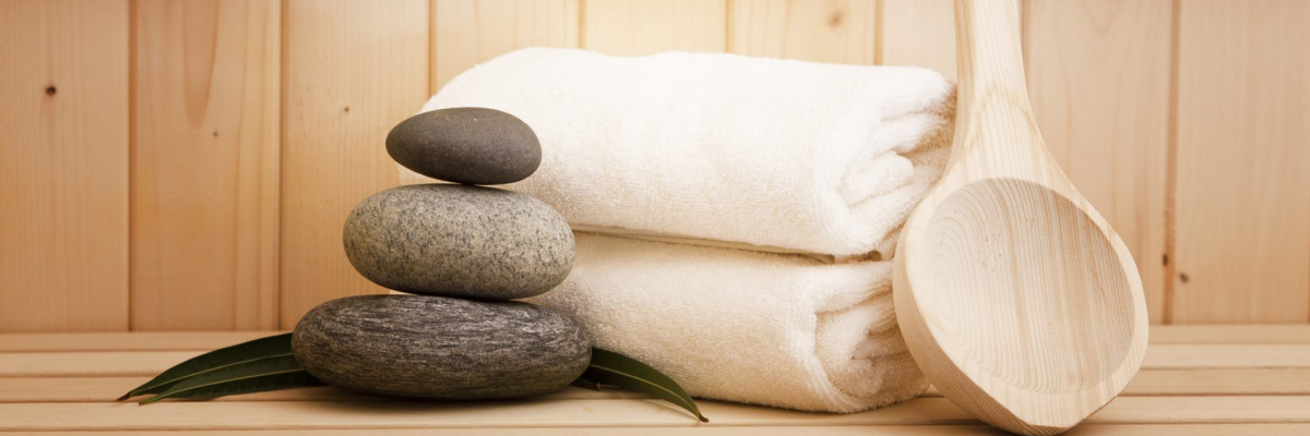 Handtücher und Steine in einer Sauna.