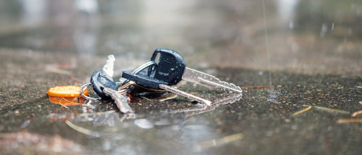 Dieses Bild zeigt einen verlorenen Schlüsselbund am Boden im Regen liegend.